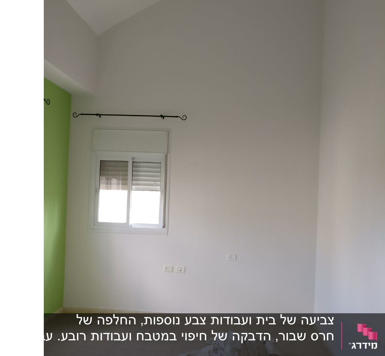 קיר צבוע בלבן וירוק עם ערימת בדים על הרצפה